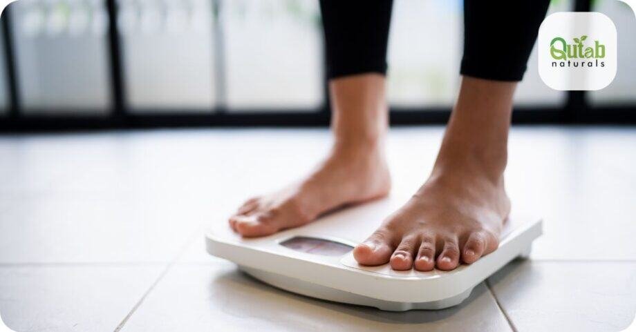 Close-up of bare feet standing on weighing scale for weight loss, with Qutab Naturals